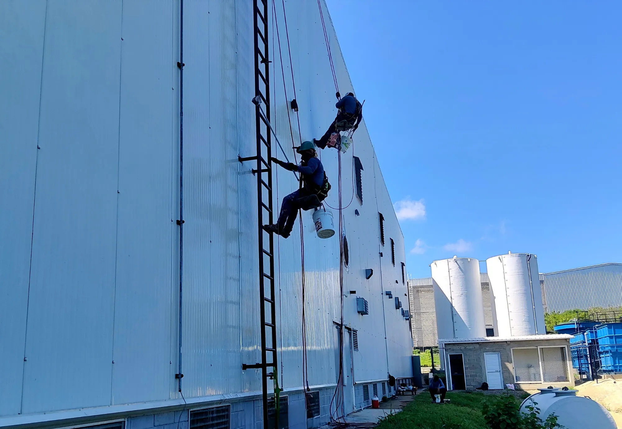 Personal técnico trabajando en altura sobre una fachada.